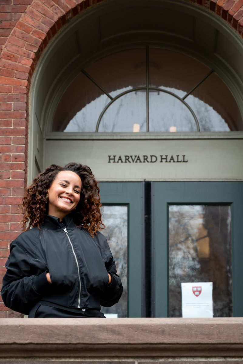 Domitila sorrindo diante do Harvard Hall
